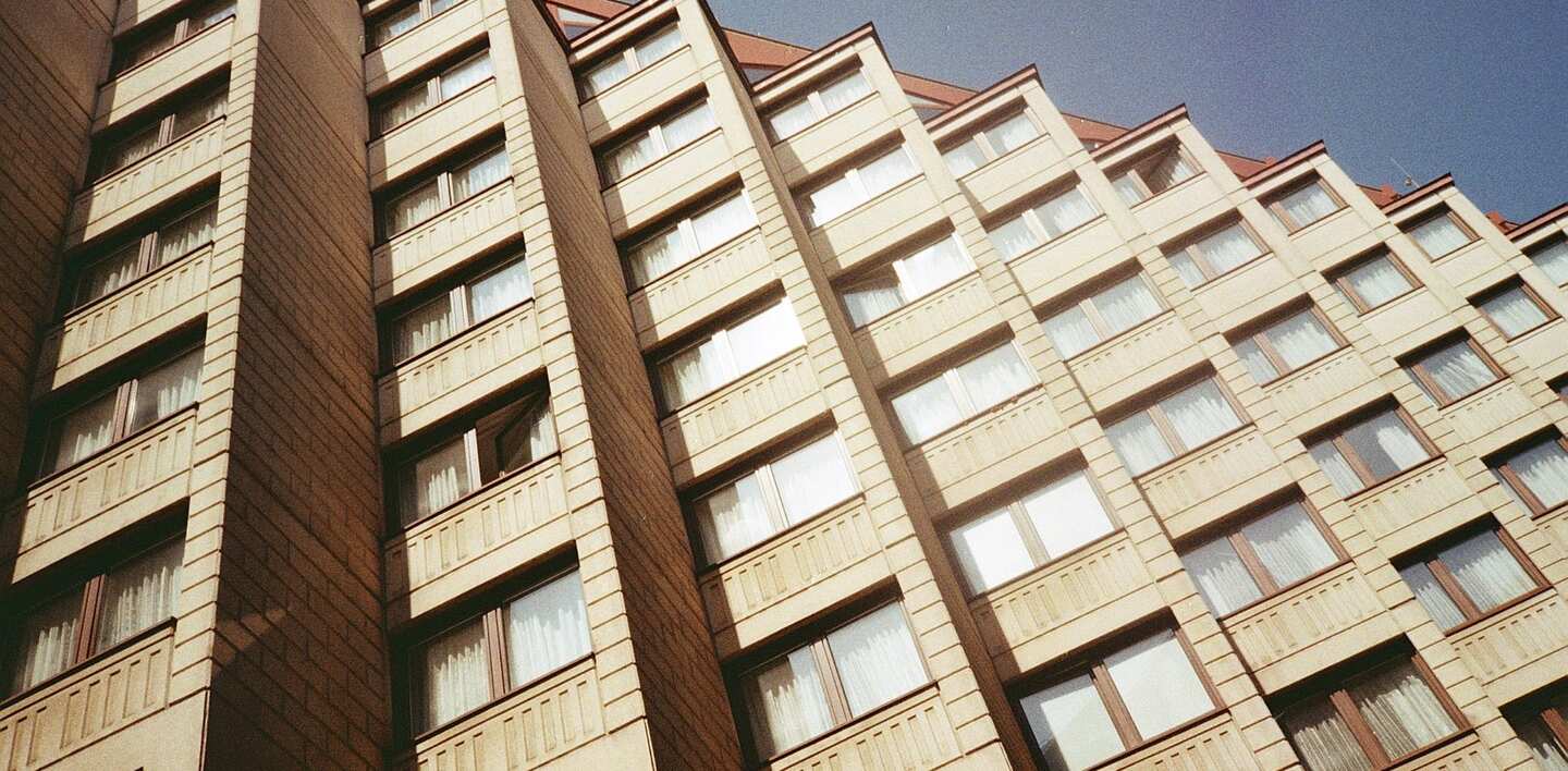 Bytový dům s řadami oken a lodžií ve slunci