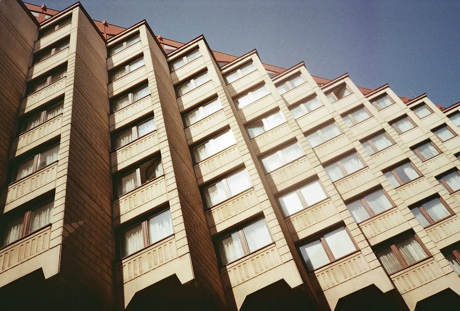 Bytový dům s řadami oken a lodžií ve slunci